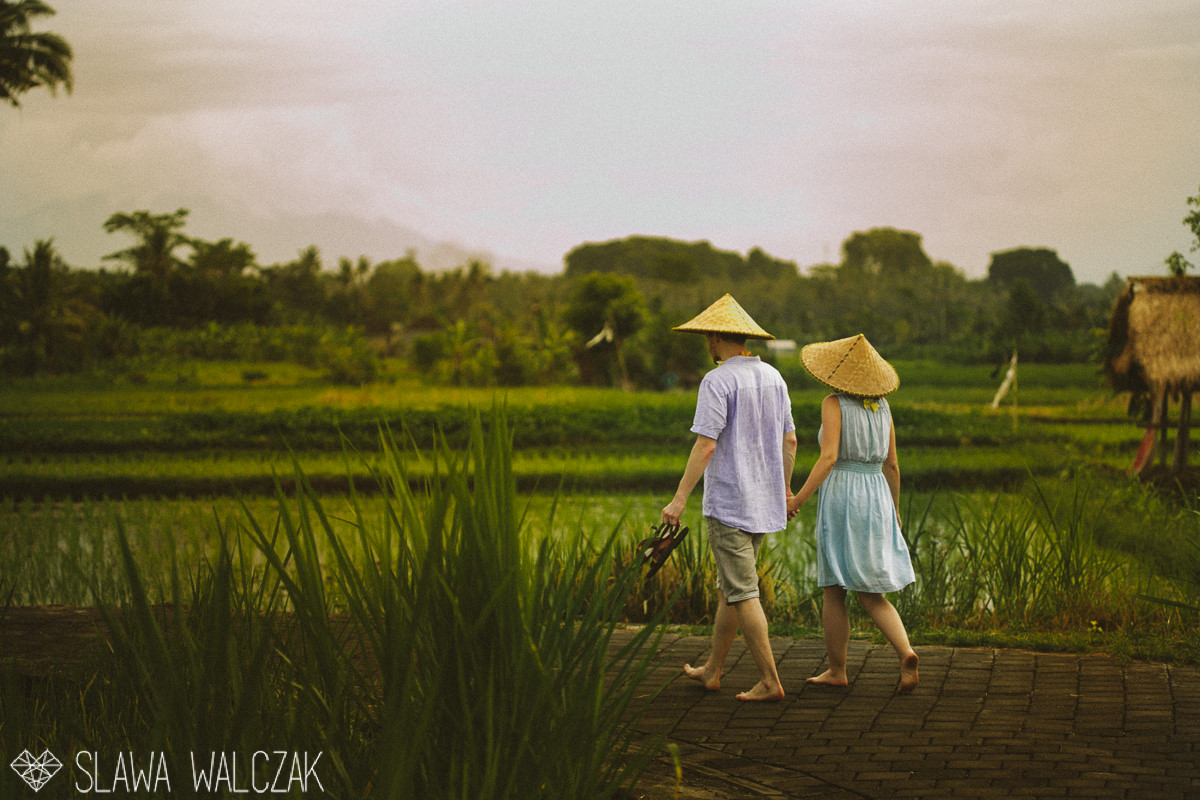 couple walking through rice paddy fileld in Ubud Bali for their engagement photo session