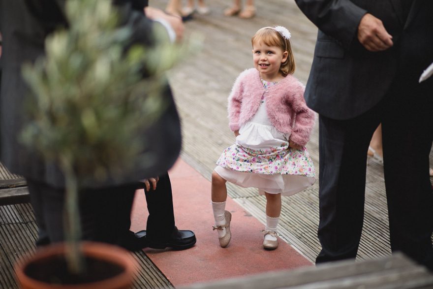 little girl posing for a photo during a wedding in Greenwich Yacht Club