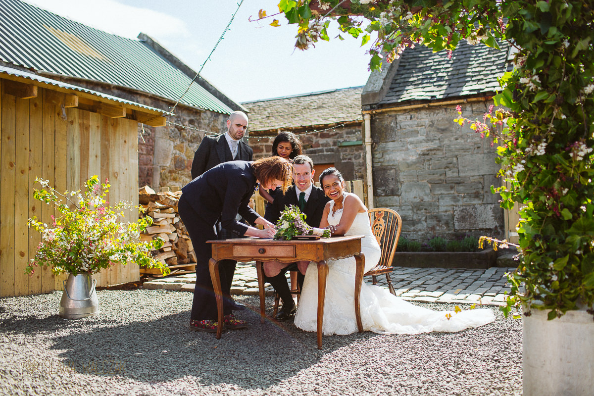 signing of a registry at a scottish wedding in Cockdurno Farmhouse