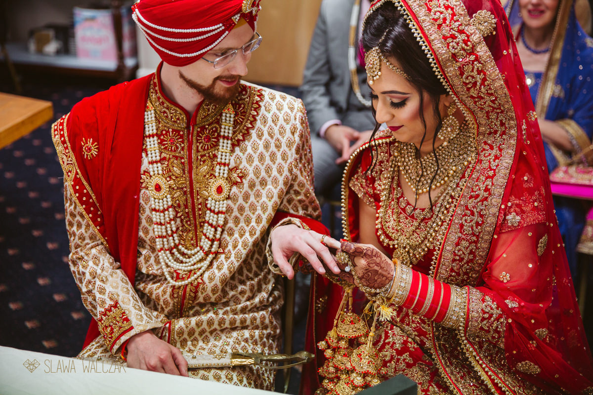 indian couple exchanges rings during their sikh wedding ceremony