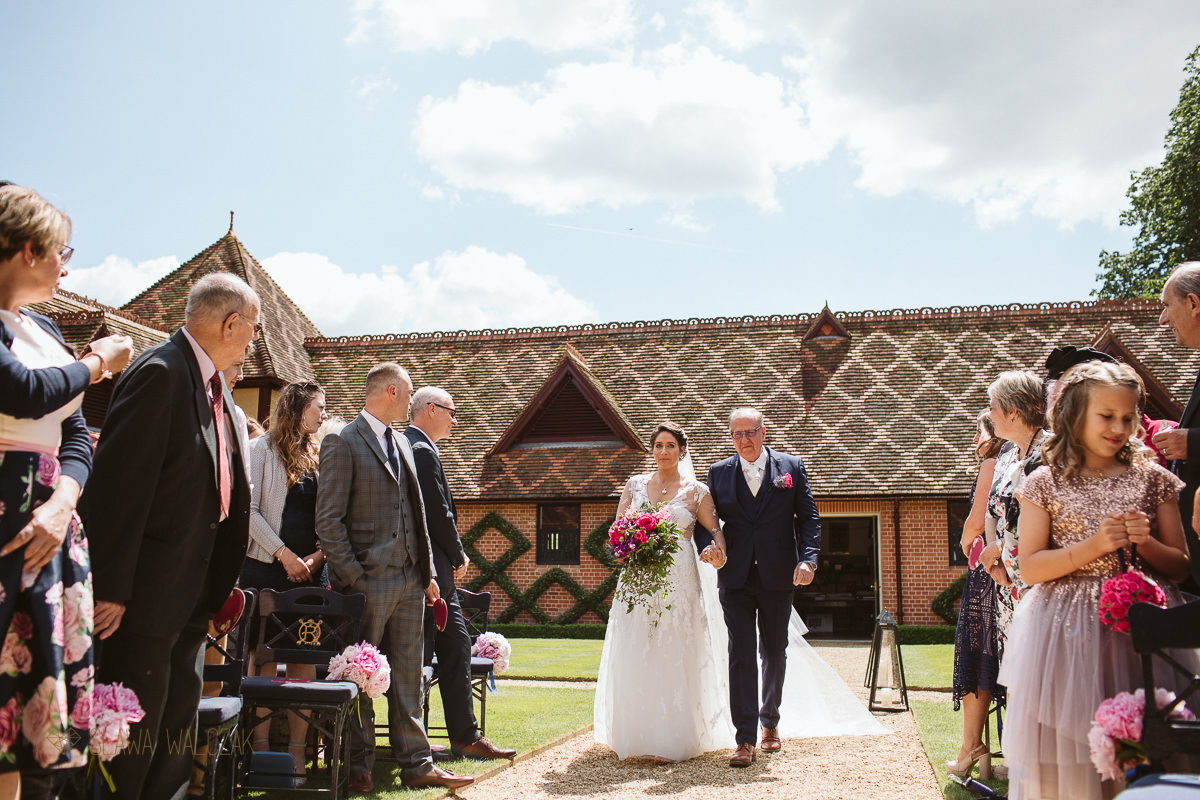 father walking the bride at an outdoor wadding in the Dairy in Waddesdon