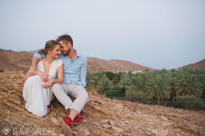 destination engagement photos of a beautiful couple in between the palm tree plantation in muscat , oman