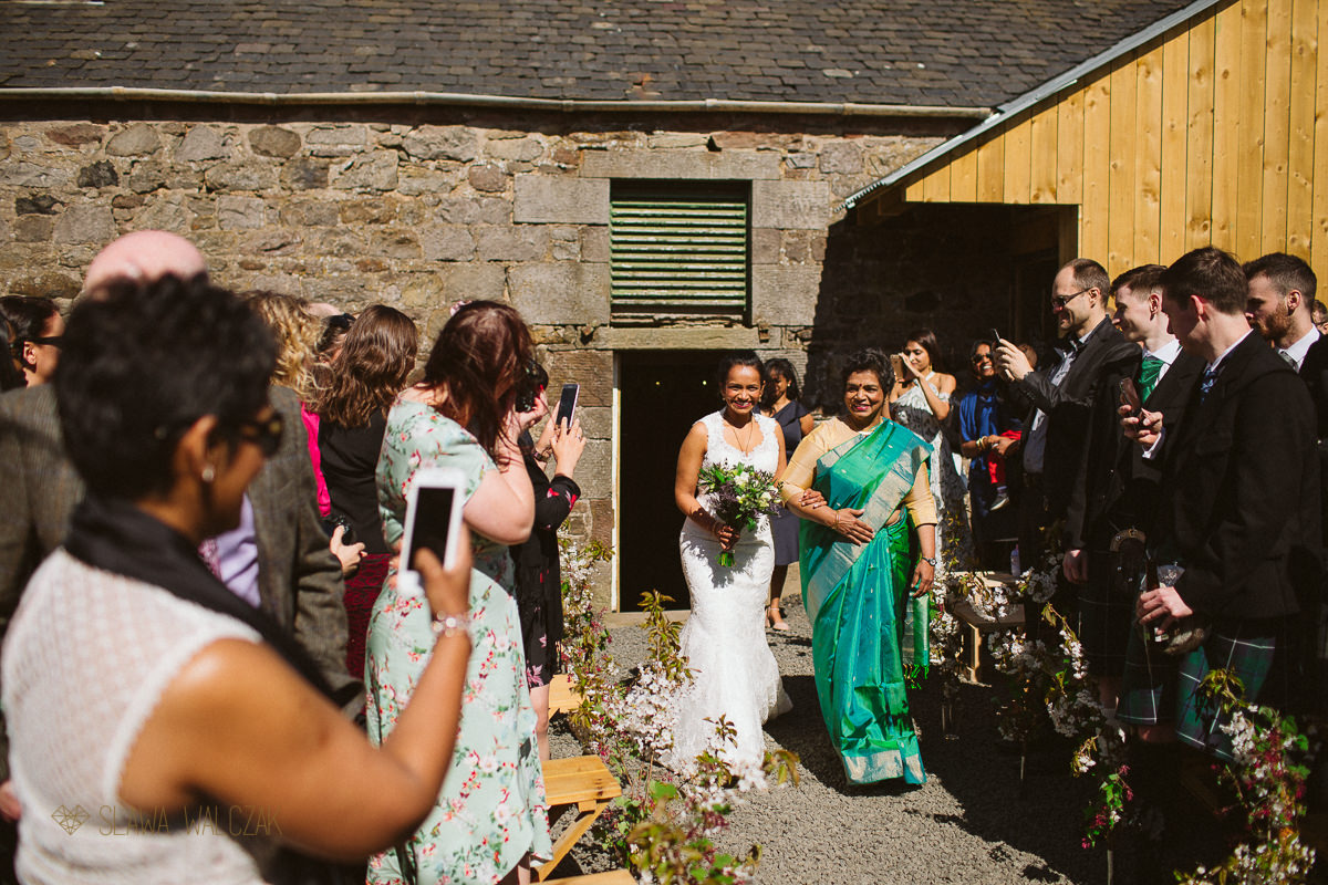 bride and her mum walk down the aisle at an Edinburgh Farm Wedding