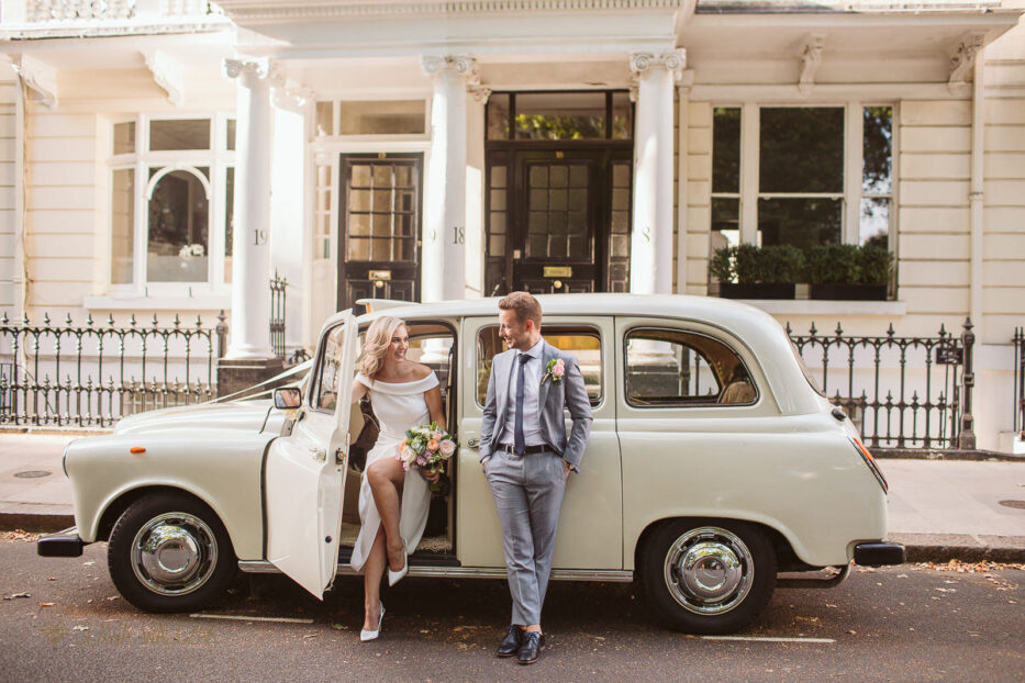 London couple posing in front of the cab outside Old Marylebone Town Hall