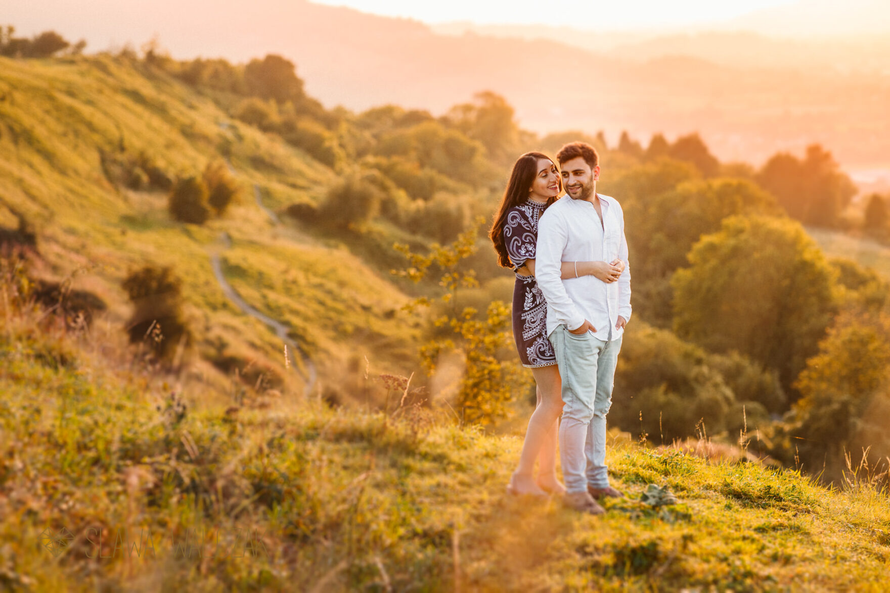 asian couple on top of a hill posing for their engagement photos during golden hour