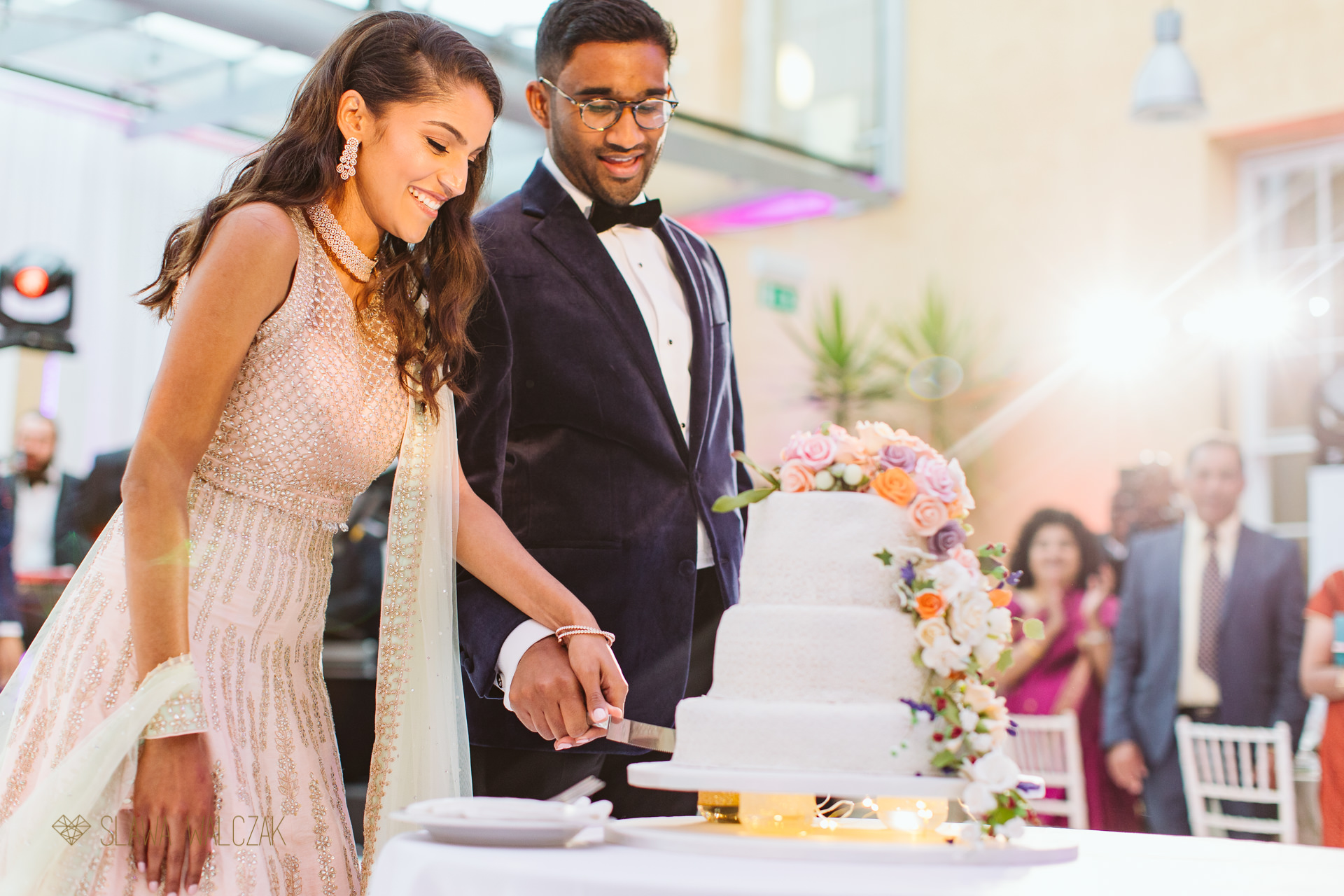 Hindu bride and a groom cut a cake at ther wedding